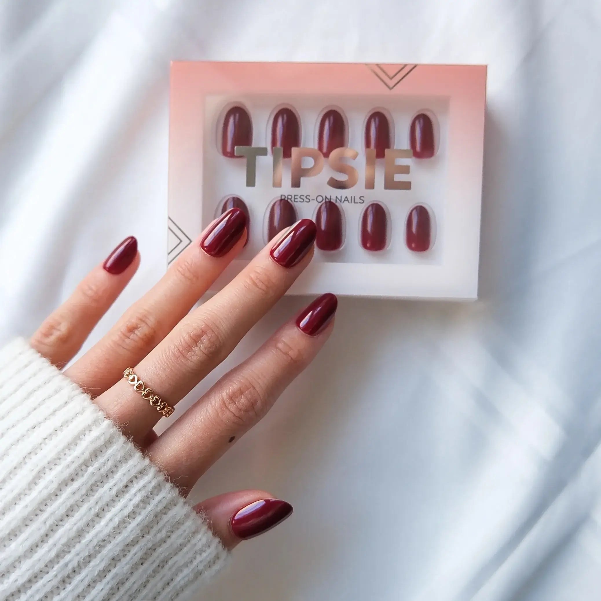 Maroon press-on nails with 'TIPSIE' packaging on a white background
